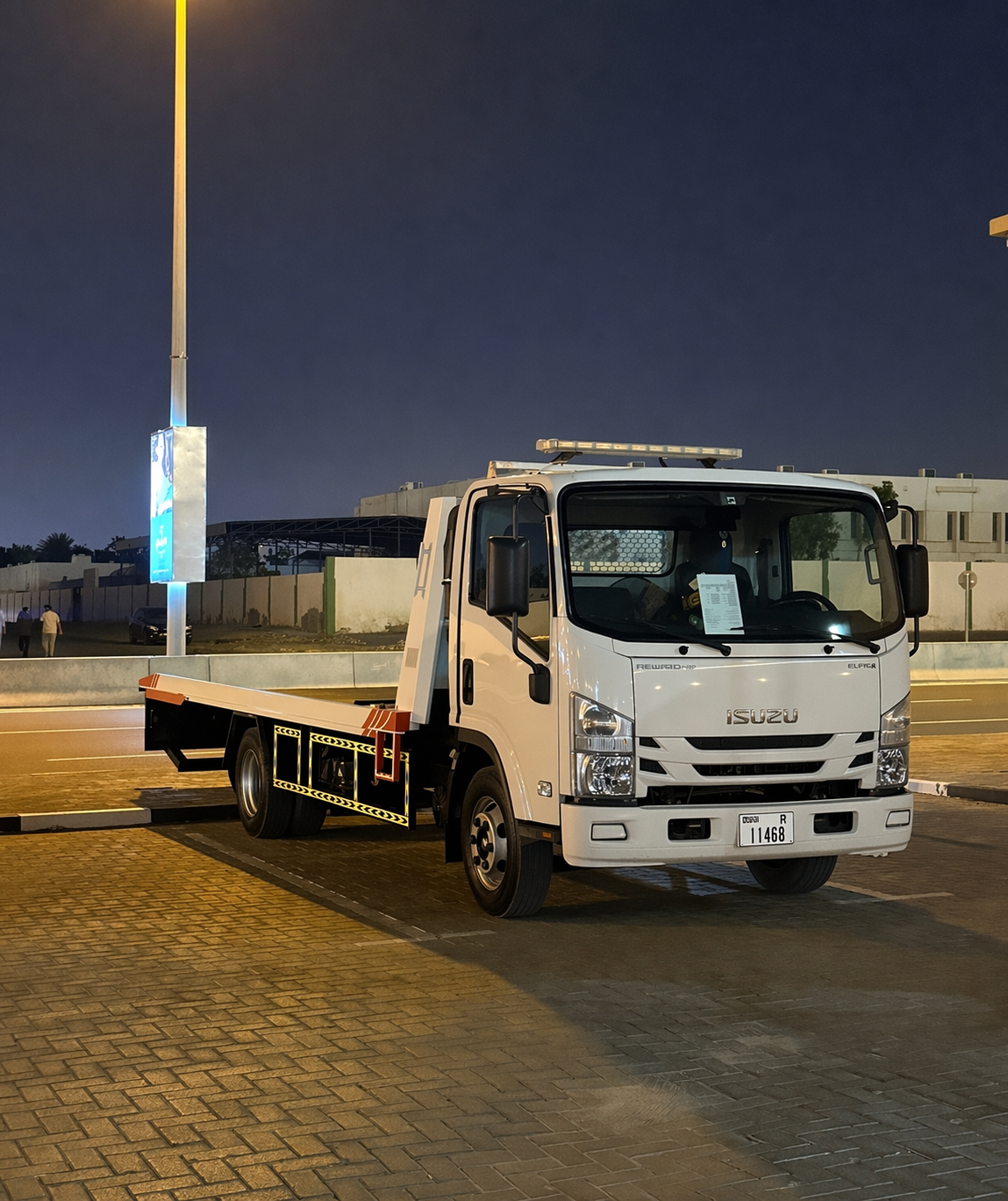 Nighttime urban roadside with tow truck
