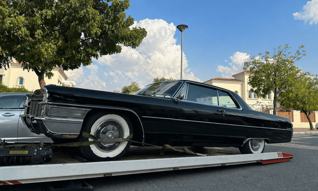 Classic car on tow truck in suburb